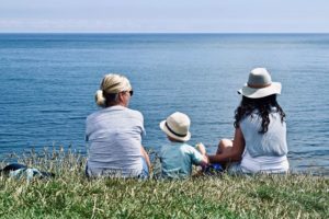 Persona mayor con familia viendo el mar